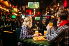 Fans watching match and drinks beer in sports bar
